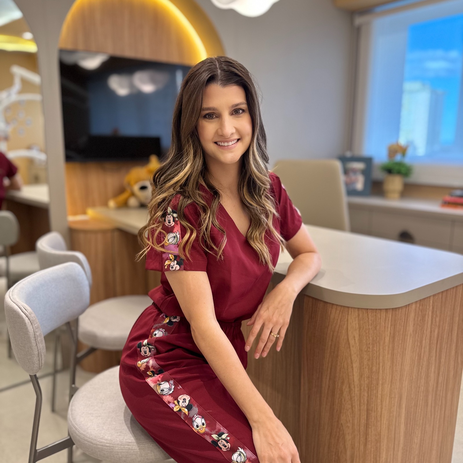 Dra. Bruna Menoncin sorrindo no consultório odontopediátrico