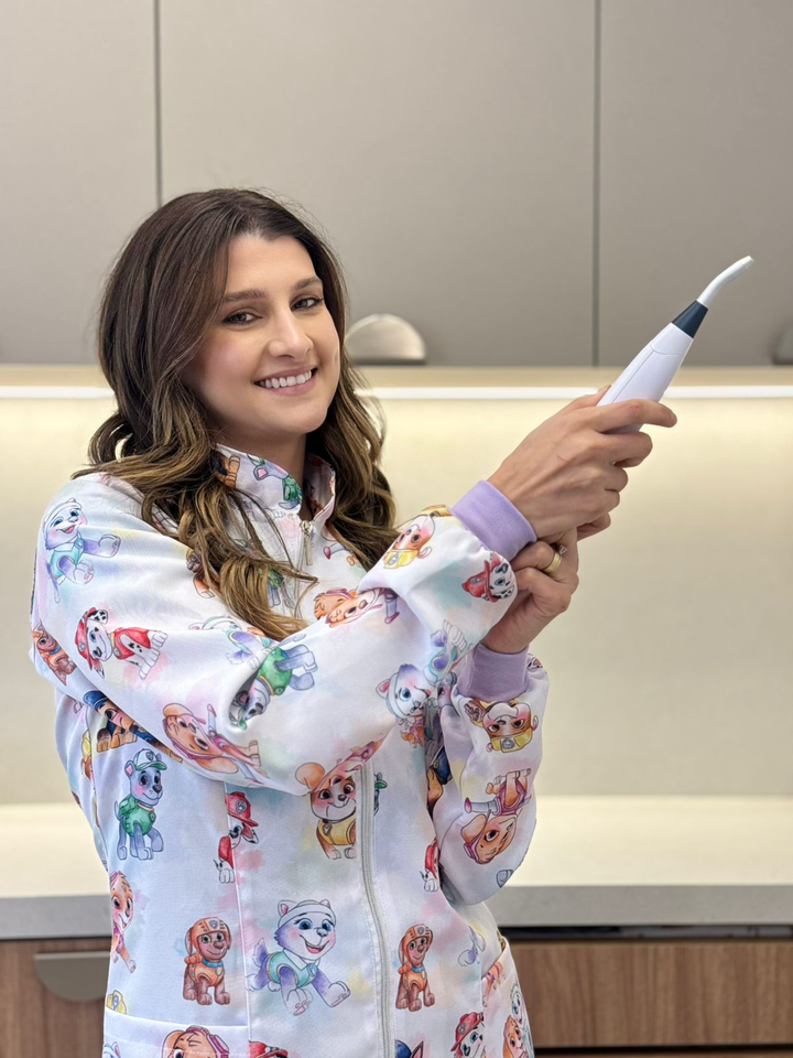 Dra. Bruna demonstrando o equipamento usado na laserterapia
